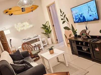 a living room with a couch and a flat screen tv at Boho Beach Vibes 2br Apt 2 in Makati in Manila