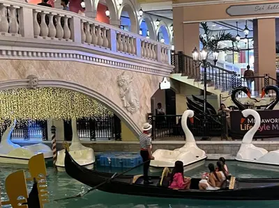 a group of people riding in a gondola in a mall at Casa Feliza Belle-veranda overlooking Venice Grand Canal Gondola ride, with pool,gym,tennis,basketball courts,sauna and massage room in Manila