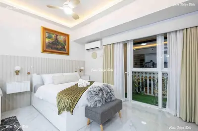 a bedroom with a bed and a chair and a window at Casa Feliza Belle-veranda overlooking Venice Grand Canal Gondola ride, with pool,gym,tennis,basketball courts,sauna and massage room in Manila
