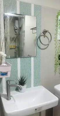 a bathroom with a sink and a mirror at Gelle Staycation in Manila