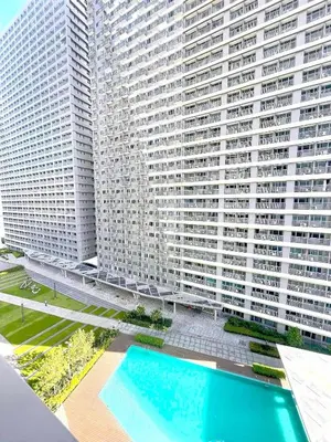 a large building with a swimming pool in front of it at Gelle Staycation in Manila