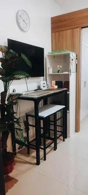 a desk with a computer and a chair in a room at Gelle Staycation in Manila
