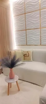 a room with a bed and a vase with a plant at Gelle Staycation in Manila