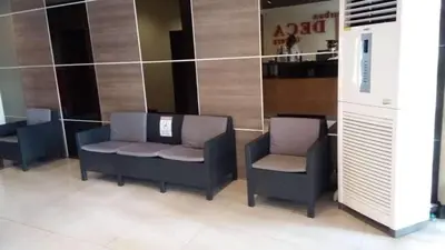 a lobby with two chairs and a counter in a store at Urban Deca Tower OYO in Manila