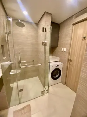 a bathroom with a shower and a washing machine at The Metro Nest at Bonifacio Civic Center Tower in Manila