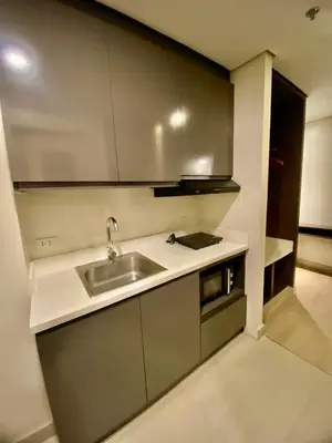 a kitchen with a sink and a counter top at The Metro Nest at Bonifacio Civic Center Tower in Manila