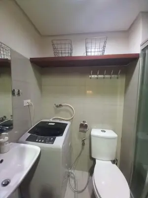 a small bathroom with a toilet and a sink at Shore Residence Pool view Mall of Asia in Manila
