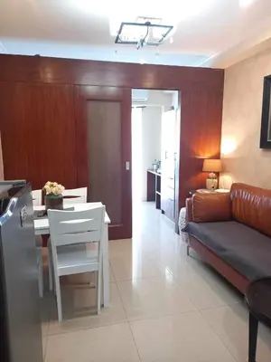 a living room with a couch and a table at Shore Residence Pool view Mall of Asia in Manila