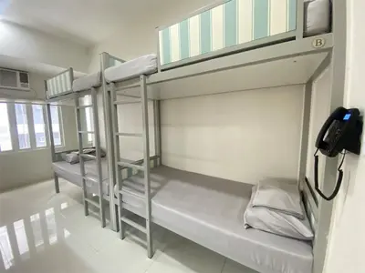 a room with three bunk beds in a building at UHome Lacson in Manila