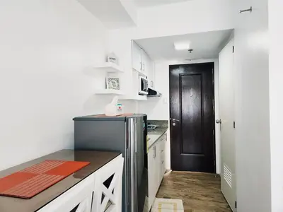 a kitchen with a black door and a refrigerator at Mannah's Place in Santo Domingo