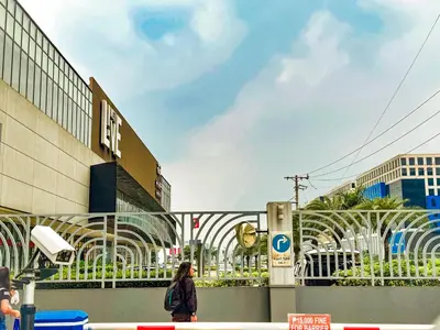 a woman walking down a street in front of a building at 826 Air Condo Comfort Suite Spacious 1BR in Manila