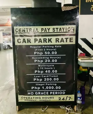 a sign for a car park rate in a store at Classy Modern Haven 1BR Air Residence Makati in Manila