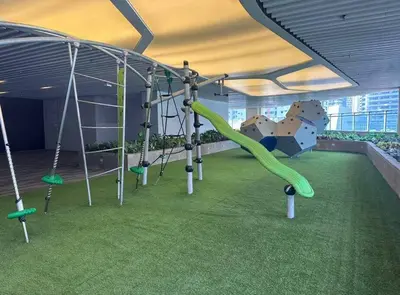 a playground with a green slide and swings at Classy Modern Haven 1BR Air Residence Makati in Manila
