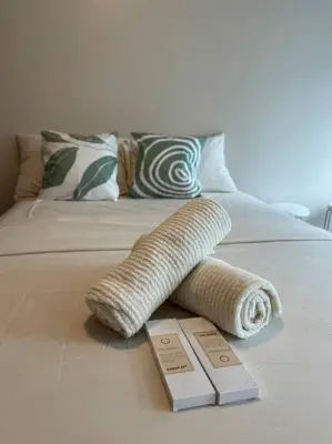 a wrapped up towel on top of a bed at Cozi Uptown 1br suite Mitsukoshi Mall BGC in Manila