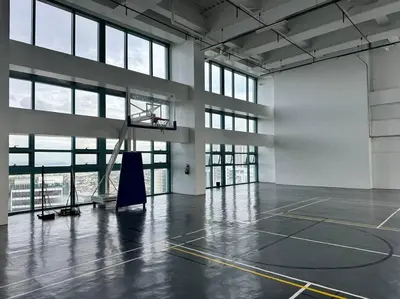 an empty gym with a basketball hoop in a building at Cozi Chic 1br Condo beside One uptown Mall BGC in Manila