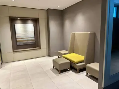 a waiting room with two chairs and a yellow seat at Cozi Chic 1br Condo beside One uptown Mall BGC in Manila
