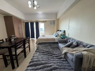 a living room with a couch and a bed at COZI Venice Luxury Residences Mckinley BGC with Pool in Manila