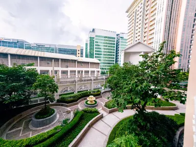 a courtyard in a city with tall buildings at COZI Venice Luxury Residences Mckinley BGC with Pool in Manila