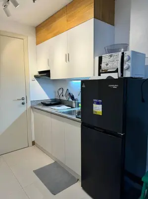 a kitchen with a black refrigerator and a sink at Las Pinas City Cozy Escape in Manila