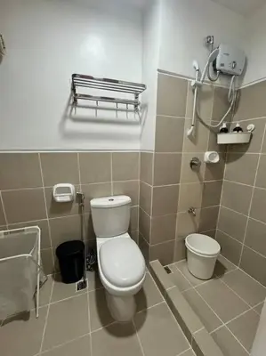 a bathroom with a toilet and a sink at Las Pinas City Cozy Escape in Manila