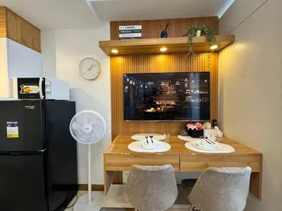 a kitchen with a table with two chairs and a refrigerator at Las Pinas City Cozy Escape in Manila