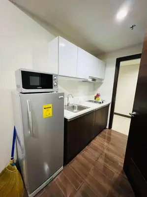 a kitchen with a stainless steel refrigerator and a microwave at 1 Bedroom Condo in Makati City in Manila