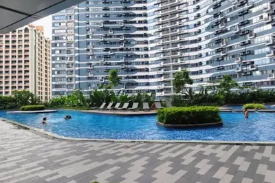 a large swimming pool in front of a large building at 1 Bedroom Condo in Makati City in Manila