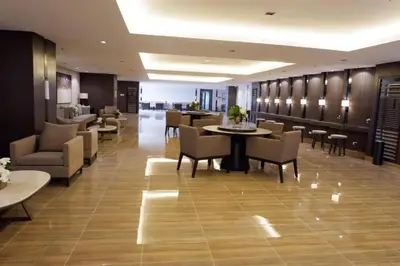 a lobby with tables and chairs and a restaurant at 1 Bedroom Condo in Makati City in Manila
