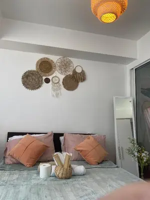 a bedroom with a bed with hats on the wall at Amethyst Suites Azure in Manila