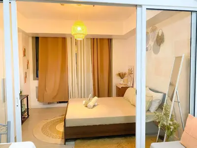 a bedroom with a bed and a glass wall at Amethyst Suites Azure in Manila