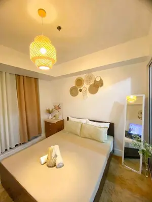 a bedroom with a large bed with shoes on it at Amethyst Suites Azure in Manila