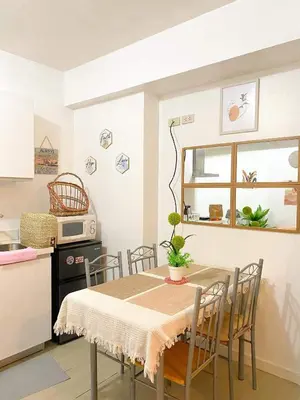 a kitchen with a table and chairs in a kitchen at Amethyst Suites Azure in Manila