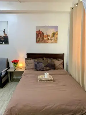 a bed with a tray with a cup on it at Cozy Condominium at Amaia Steps Nuvali in Pitland