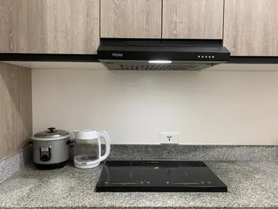 a kitchen with a counter top with a stove top oven at Cozy Condominium at Amaia Steps Nuvali in Pitland