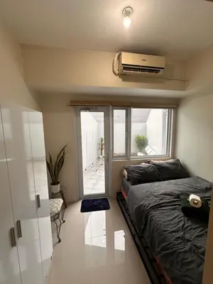 a small bedroom with a bed and a window at Cozy Brio the 2nd Sm Jazz Makati in Manila