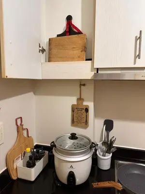 a kitchen counter with a slow cooker on a stove at Cozy Brio the 2nd Sm Jazz Makati in Manila