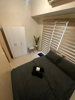 a bedroom with a large bed and a window at Cozy Brio the 2nd Sm Jazz Makati in Manila