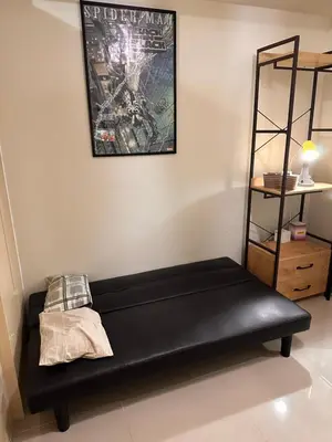 a black couch in a room with a picture on the wall at Cozy Brio the 2nd Sm Jazz Makati in Manila