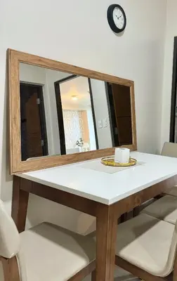 a dining room table with a mirror on the wall at Cozi 1br suite Grand Hyatt BGC wifi pool in Manila
