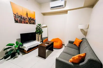 a living room with a couch and a table at Cozi 1br suite Grand Hyatt BGC wifi pool in Manila