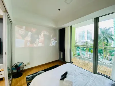 a bedroom with a large window and a large screen at 1 Bedroom azure beachview 3 in Manila