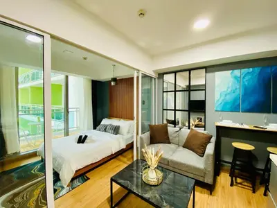 a bedroom with a bed and a couch and a table at 1 Bedroom azure beachview 3 in Manila