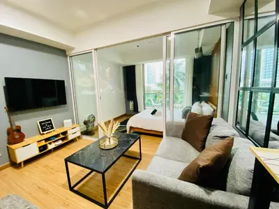 a living room with a couch and a tv and a bed at 1 Bedroom azure beachview 3 in Manila