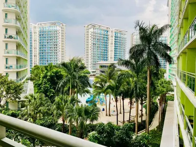 a view from the balcony of a resort with palm trees and a pool at 1 Bedroom azure beachview 3 in Manila