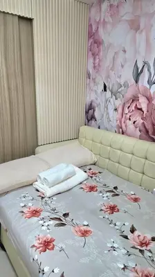 a bedroom with a bed with a floral wallpaper at Shore 2 Tower 3 Condo near MOA by Dei Gratia in Manila