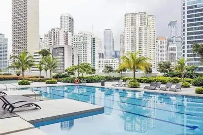 a large swimming pool with a city in the background at The Suite Life - Level 42 at Makati in Manila