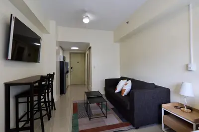 a living room with a couch and a table at The Suite Life - Level 42 at Makati in Manila