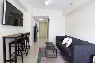 a living room with a couch and a table at The Suite Life - Level 42 at Makati in Manila