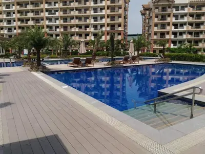a large swimming pool with chairs and a large building at 3BR Condo Unit at Mirea Residences in Manila