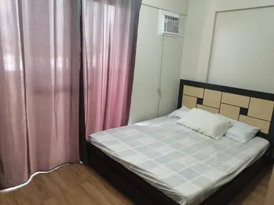 a bed in a room with curtains and a bed sidx sidx sidx at 3BR Condo Unit at Mirea Residences in Manila